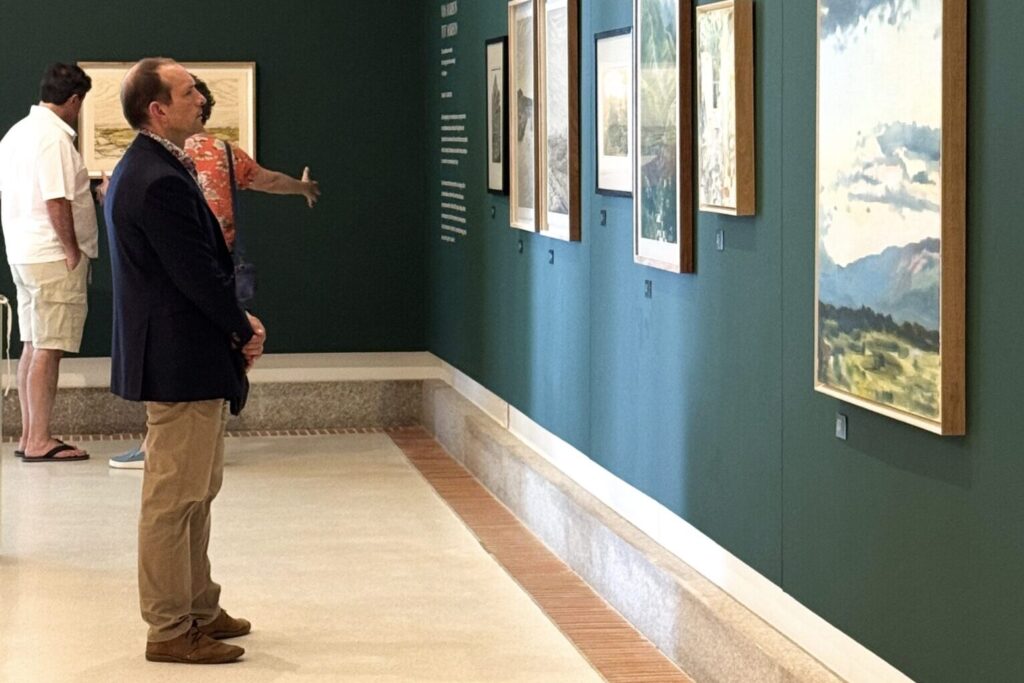 A man standing in front of artwork at La Motte Ateljee